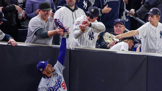 Fans try to grab ball from Dodgers' Mookie Betts in World Series Game 4; Interference called