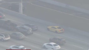 Yellow Ford mustang weaves through LA traffic