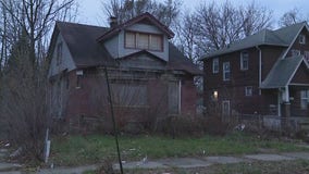 Detroit police officers help clear out debris from front yard