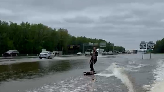 Viral video shows surfboarder's wild ride on flooded Arkansas interstate
