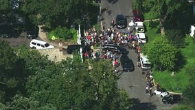 Crowds gather outside Walz's residence as black SUVs depart [RAW]