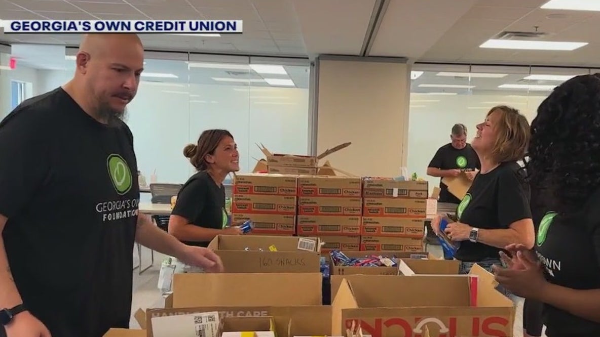 Volunteers pack food for kids