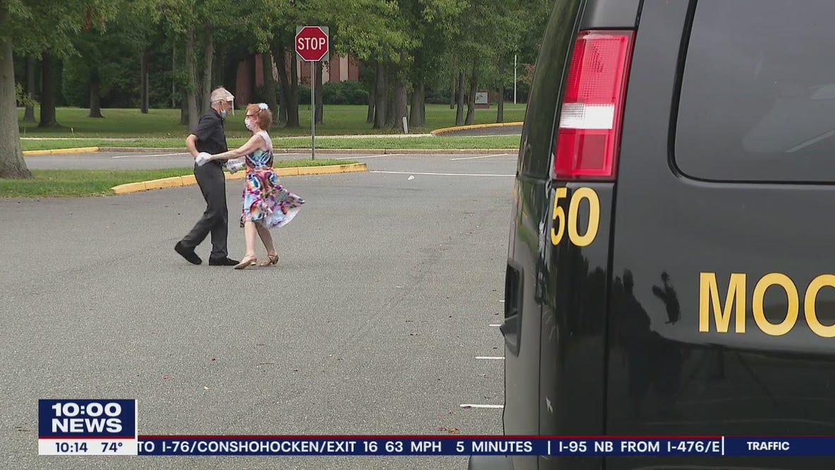Duo ballroom dances several times a week in empty high school parking lot