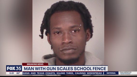 Man with gun scales school fence
