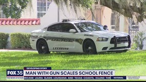 Man with gun scales school fence