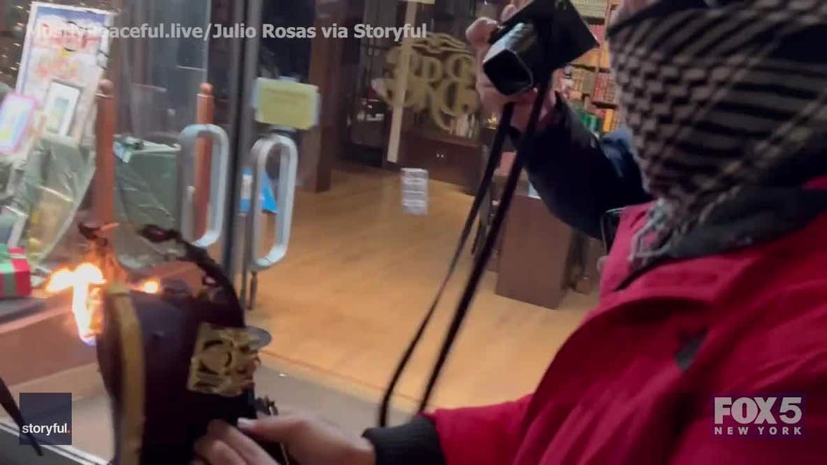 Pro-Palestinian protester shows off burning NYPD hat