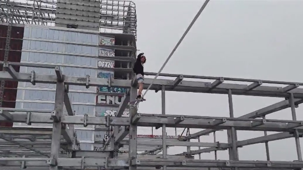 Man tightropes between DTLA graffiti towers