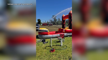 Firefighters make kids' day by hosing down bouncy slide