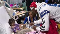 Dallas Cowboys players and cheerleaders bring gifts to kids in local hospitals