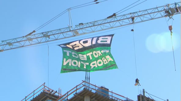 Women's March supporters climb crane in DC to unveil banner protesting Roe v. Wade decision