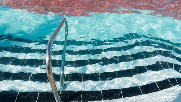 Toddler rescued after riding bike into swimming pool