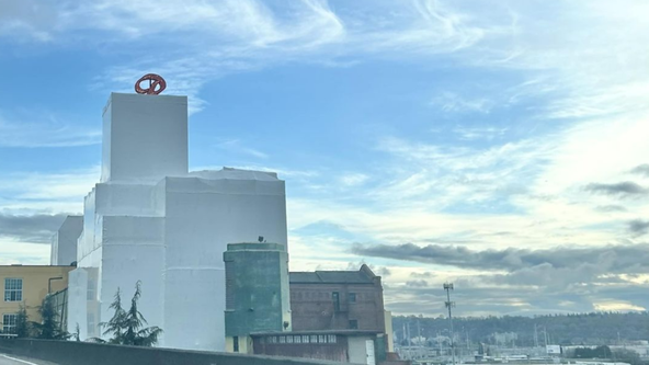 Why is the old Rainier Brewery building wrapped in white plastic?