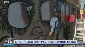 Artist "Sand One" paints a new doll mural