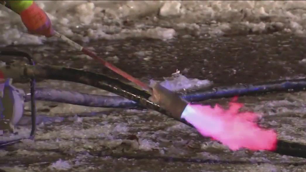 Crews use blowtorches to break up ice after water main break in Uptown