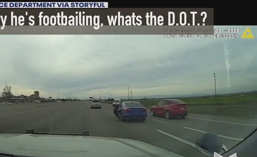 Video: Suspect clings to moving car while being chased by police