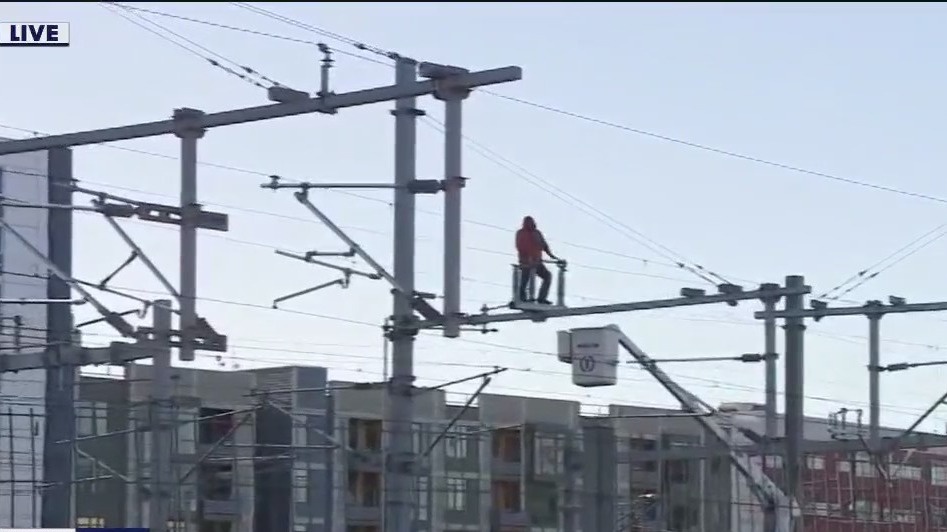 Man climbs power lines above Caltrain in San Francisco