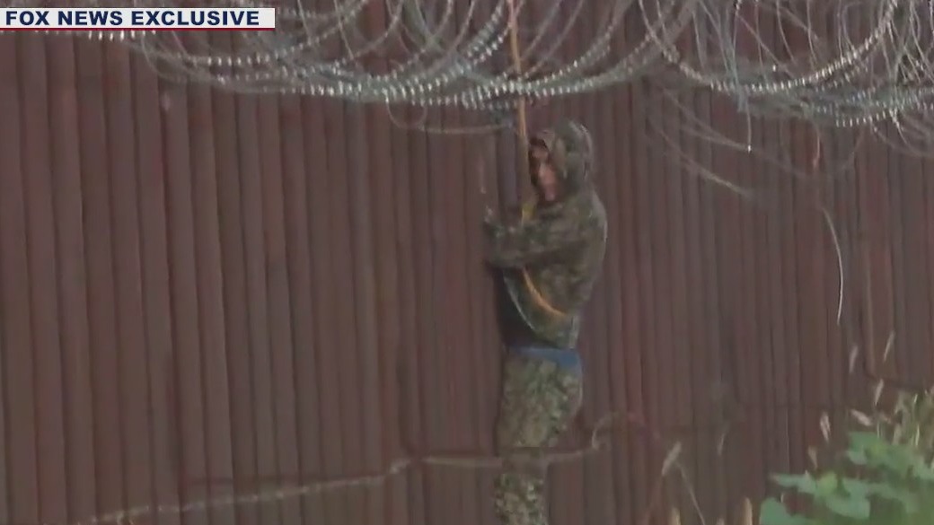 Caught on camera: Migrants dressed in camo scale Arizona border wall