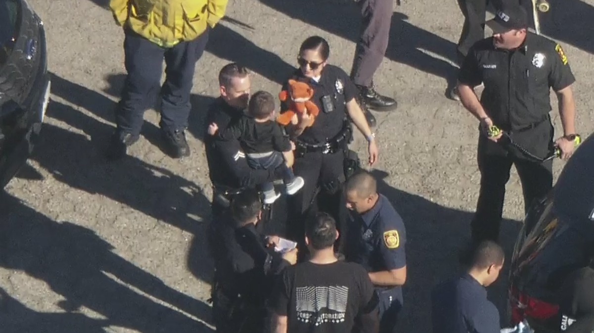 LAPD officers comfort child from Panorama City police scene