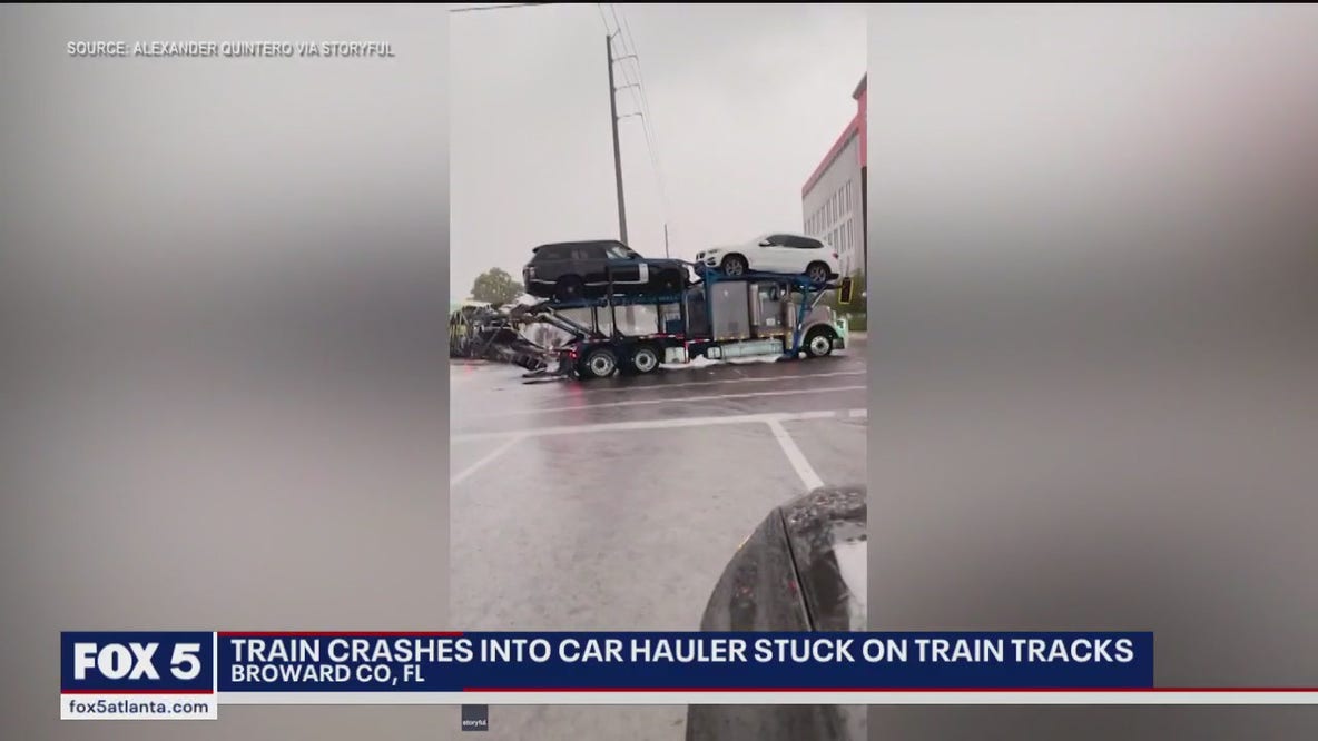 Train crashes into car hauler stuck on tracks
