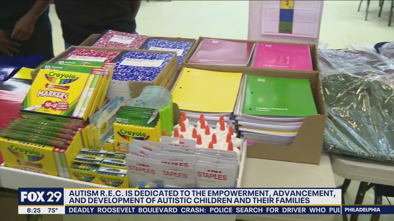 Autism R.E.C. holding backpack and school supply giveaway