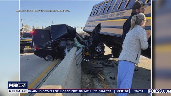 Crews work frantically to free driver after crash with school bus