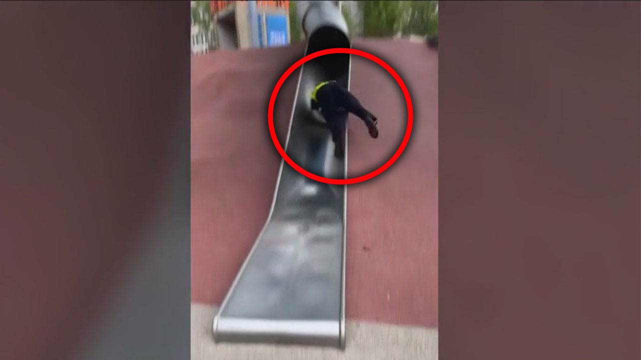 Cop goes viral for his trip down playground slide