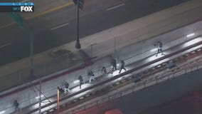 Protesters run along train tracks to avoid police
