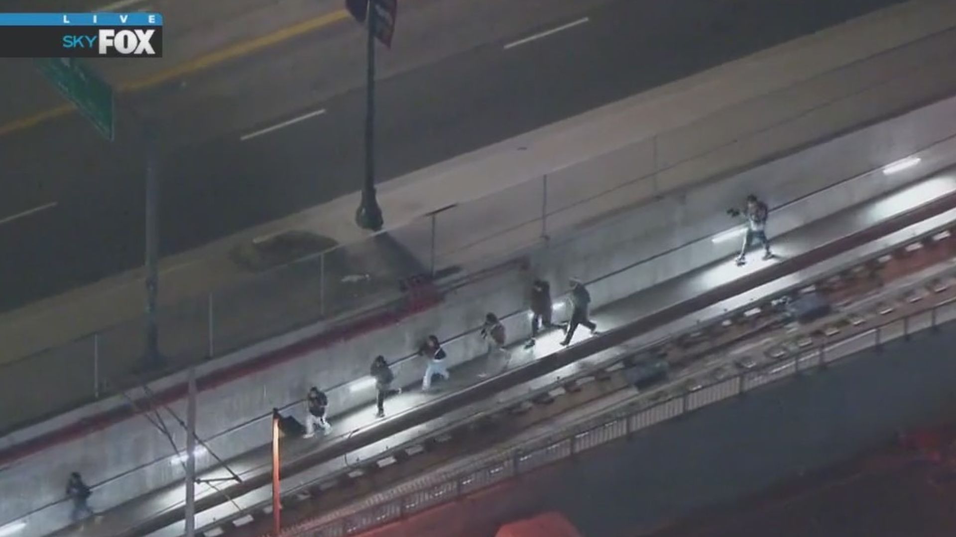 Protesters run along train tracks to avoid police