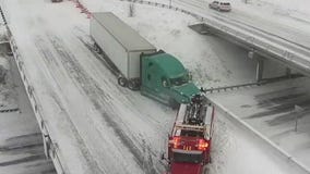 Teetering semi-truck towed back onto bridge