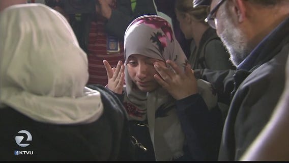 Travelers arrive in US to hugs and tears after ban is lifted