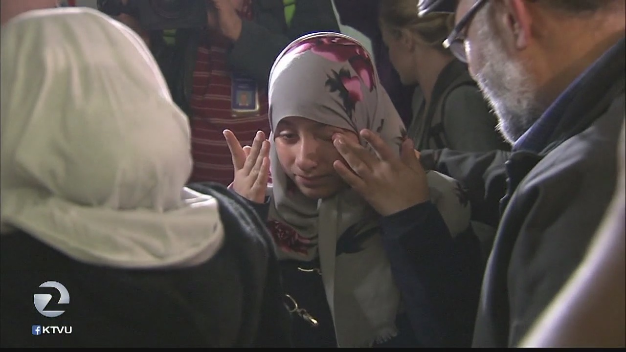 Travelers arrive in US to hugs and tears after ban is lifted