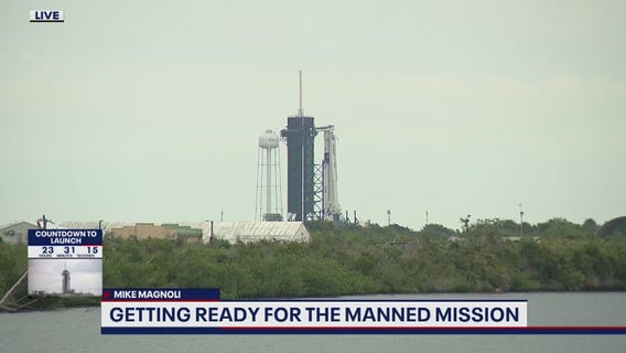 Falcon 9 rocket hoisted back in upright position after servicing