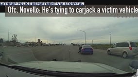 Suspect clings to car during police chase