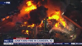 Crews work to extinguish massive junkyard fire