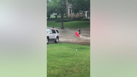 Residents in Ellicott City boogie board through flood waters