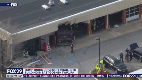 Dump truck drives off road into building