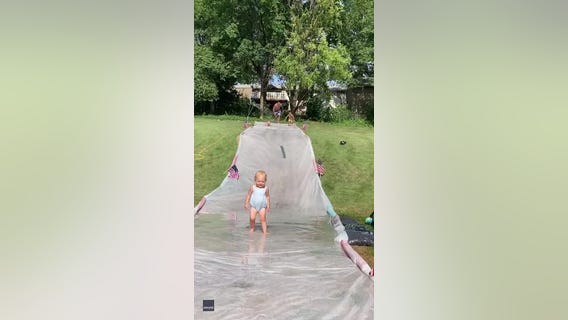 Dad displays cat-like reflexes as he catches toddler on slip 'n slide
