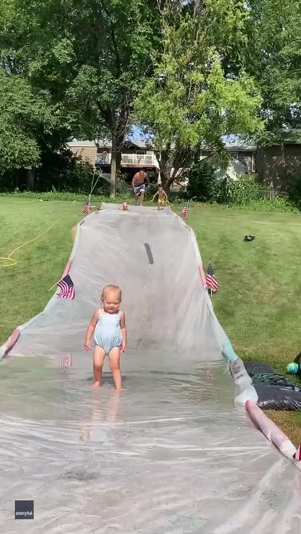Dad displays cat-like reflexes as he catches toddler on slip 'n slide