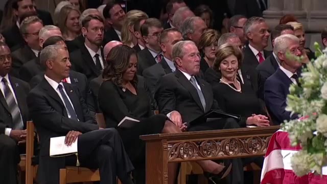 George W. Bush passes candy to former First Lady Michelle Obama at McCain Memorial Service