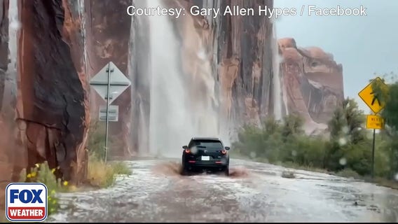 Travelers in Utah drive through waterfalls caused by flash flooding