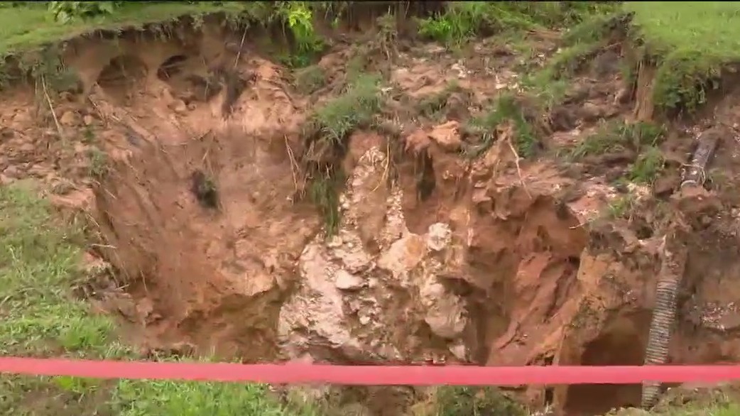 Massive hole opens inches away from home