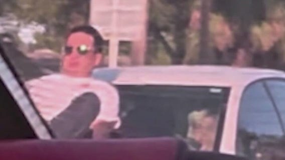 Man clings to hood of vehicle speeding down the road in Cocoa