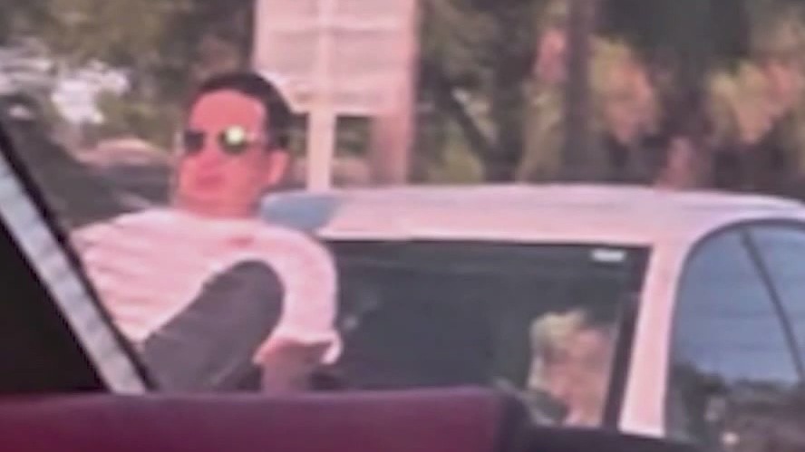 Man clings to hood of vehicle speeding down the road in Cocoa