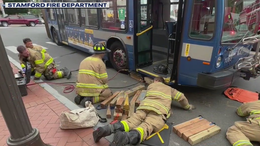 Firefighters save woman pinned under bus