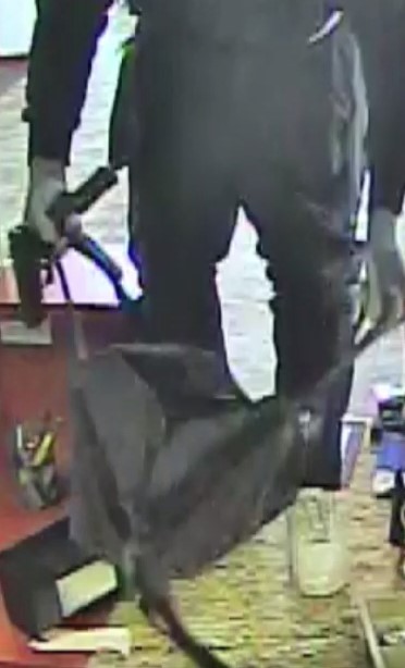 Video shows armed suspect hop on counter at bank, steal money