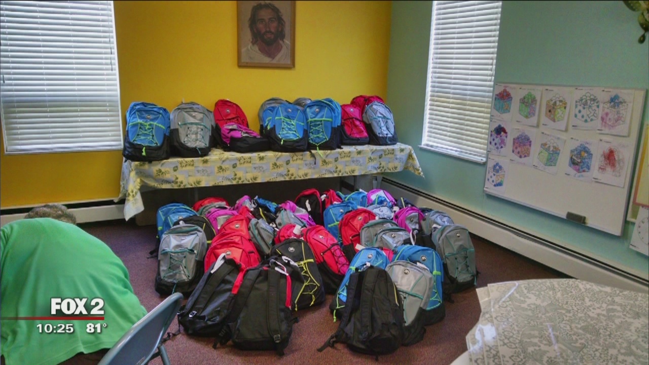 Young girl continues filling backpacks with school supplies