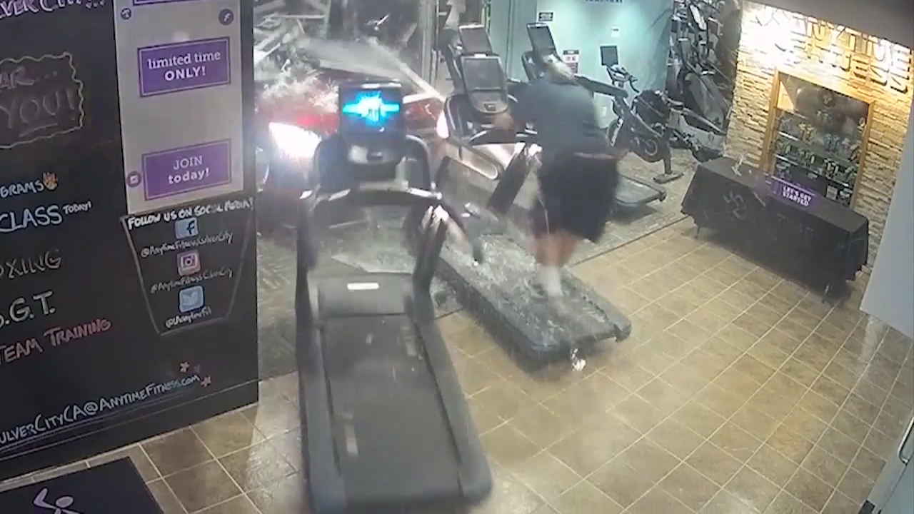 Car crashes through gym pinning man between treadmill and wall