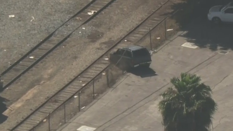 SUV plows through fence, drives along train tracks in South LA area