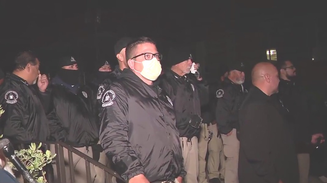 Private security standing still amidst chaos