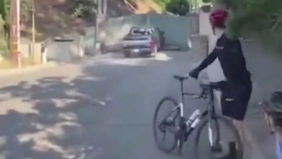 Driver hits cyclist, smashes through gate